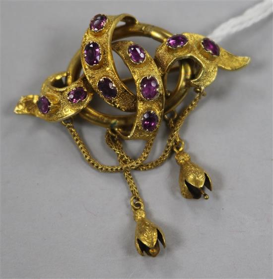 A Victorian textured high carat gold and amethyst or garnet scrolling drop brooch, 4cm.